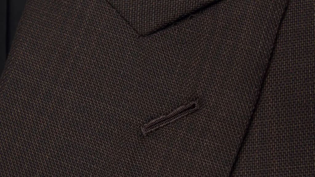 Close-up of a brown birdseye wool jacket lapel and welted pocket tailored by Lahza in Al Karama, Dubai